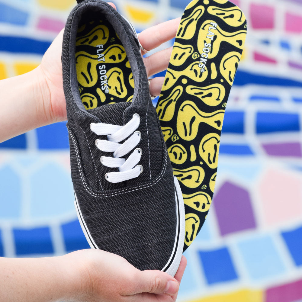 Woman holding up grey fabric converse-type shoe with pair of Happy Days FLAT SOCKS #size_small-up-to-women-s-11-men-s-10