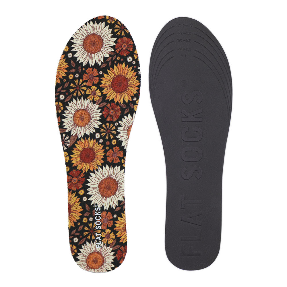 View of top fabric on left liner, view of bottom of right liner. Insole liner features amber, yellow, and pale yellow sunflower floral print on top fabric. Bottom of FLAT SOCK is 100% black polyurethane foam and provides slight cushion under foot and its super grippy surface helps liner stay in place all day #size_small-up-to-women-s-11-men-s-10