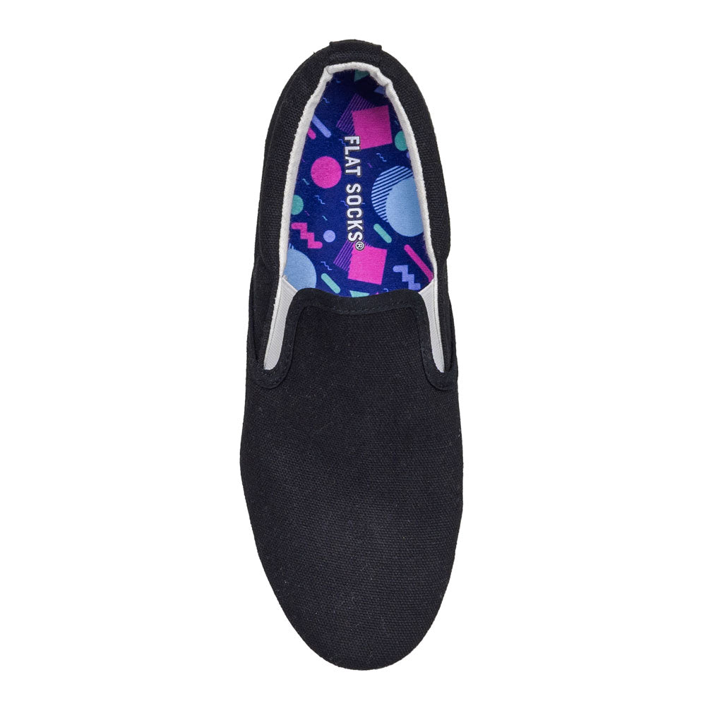 Dark blue with 1980s and 1990s Memphis style print FLAT SOCK in black flat slip-on shoe. Insole liner features fuchsia, teal, purple, and light-blue Memphis style shapes on top fabric. Shoe liner is made of 100% polyester knit micro-pile, which is a material closest to a traditional sock, helps protect and extend life of shoes. #size_large-up-to-women-s-13-men-s-14