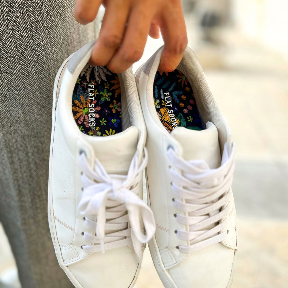 Person holding a pair of white sneakers with Floral Embroidery FLAT SOCKS inside #size_small-up-to-women-s-11-men-s-10